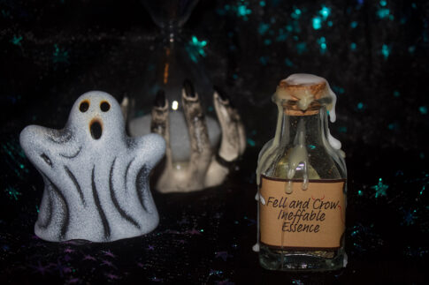 A product photo of a spell jar with the label "Fell and Crow Ineffable Essence" in the right background is a ceramic ghost and hourglass.