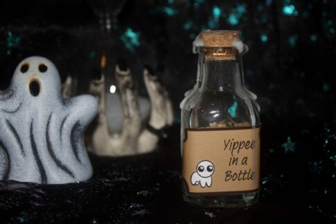 A product photo of a spell jar with the label "Yippee in a bottle" in the right background is a ceramic ghost and hourglass.